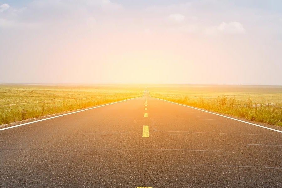 An empty road with grass fields on either side