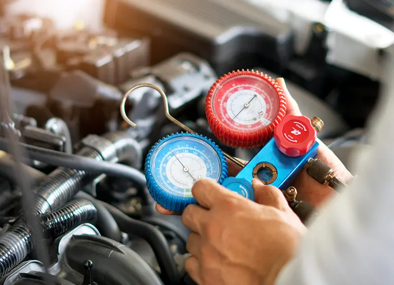 A mechanic working on a car's air conditioning system